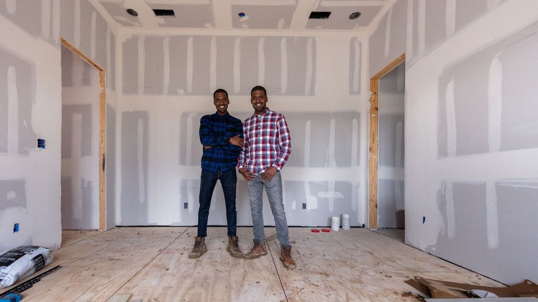 Chris and Calvin LaMont standing in unfinished room