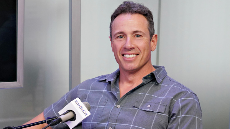 Chris Cuomo smiling next to a microphone