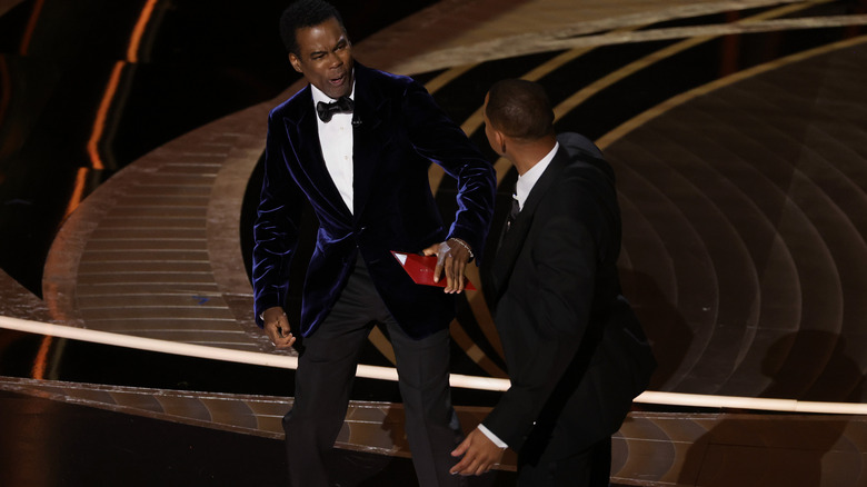 Chris Rock reacts after being slapped by Will Smith at the Oscars