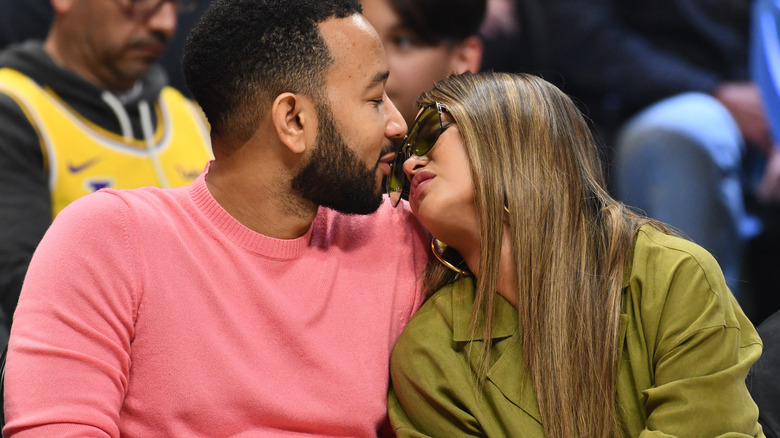 Chrissy and John kissing at a basketball game