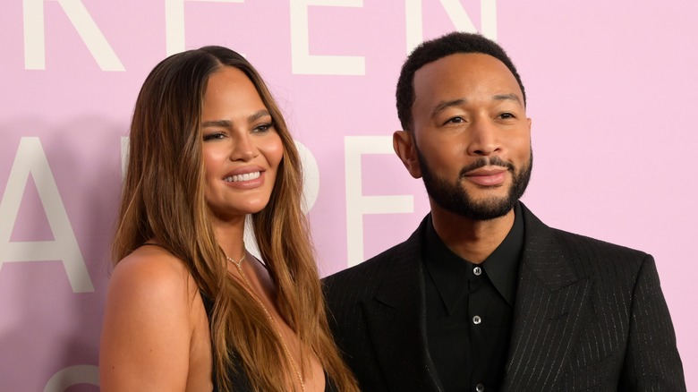 Chrissy Teigen smiling; John Legend in black tux