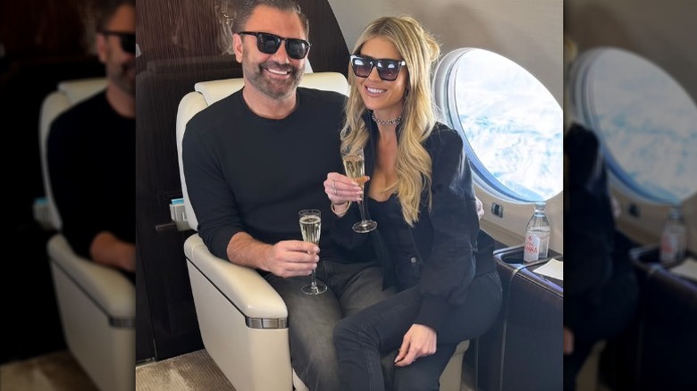 Christina Haack sitting on Christopher Larocca's lap in a private plane, holding champagne flutes