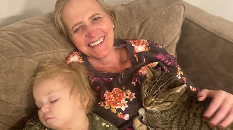 Christine Brown posing with her granddaughter and cat