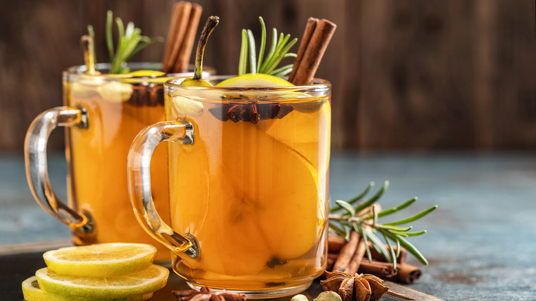 Two glasses of hot toddies garnished with cinammon sticks