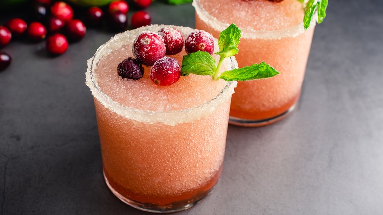 Frozen cranberry margaritas garnished with frozen cranberries and mint