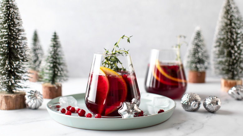 Sangria with lemon wedges surrounded by pine trees