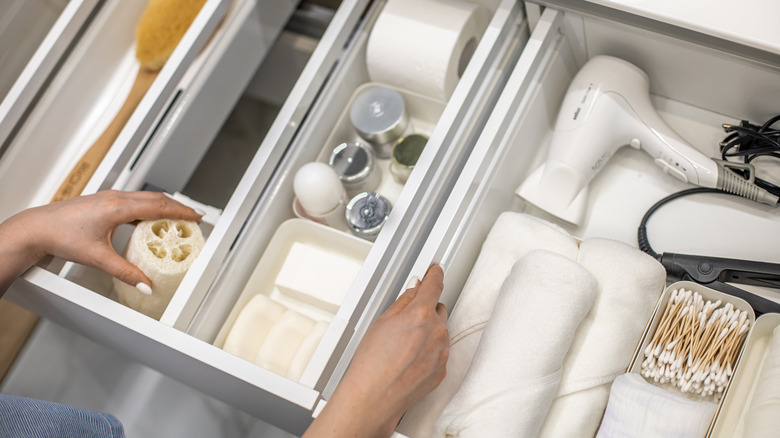 hands organize bathroom drawer