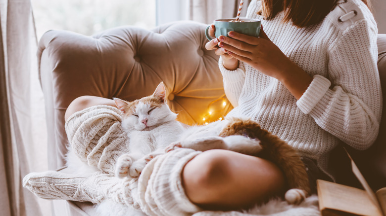 woman cozy with her cat on a couch