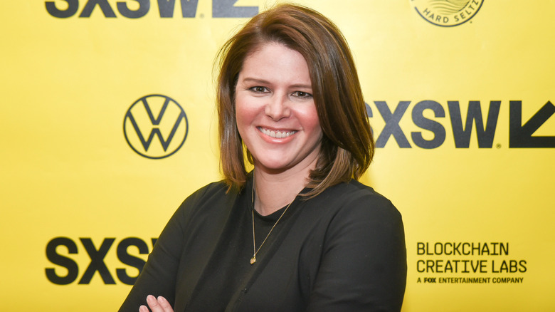 Kasie Hunt smiling in front of yellow backdrop