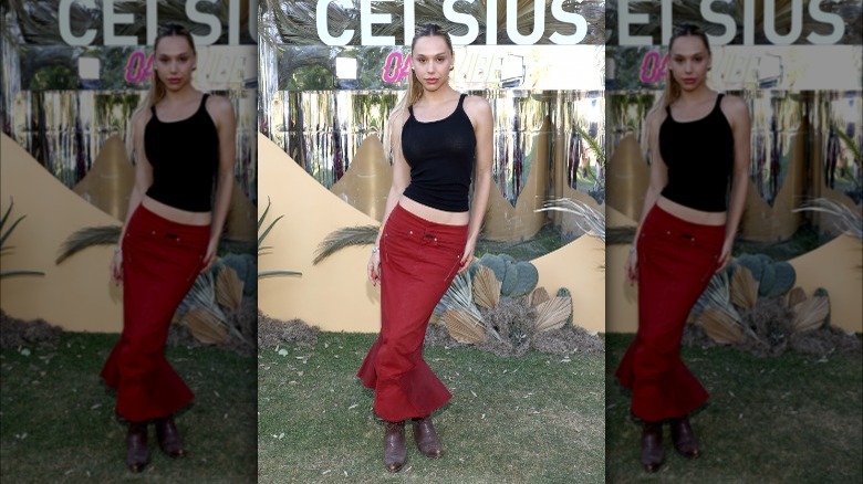 Alexis Ren posing in front of sign