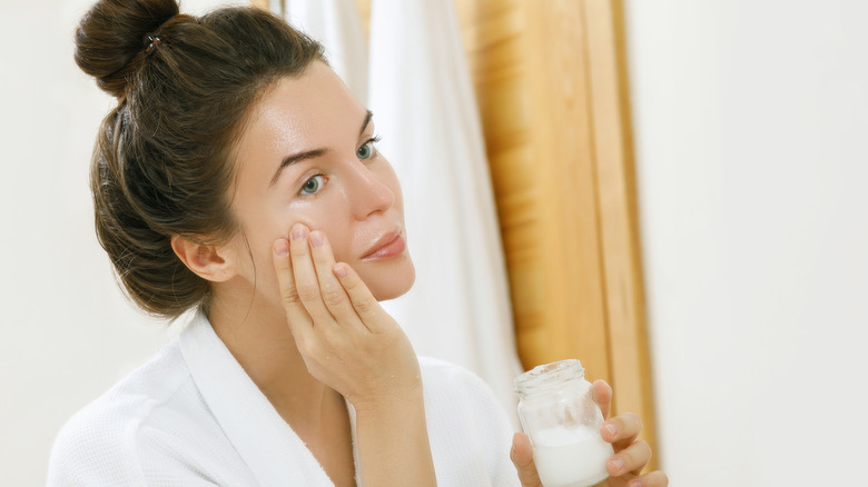 Woman applying coconut oil 