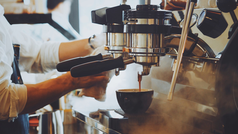 Barista brewing espresso at the machine