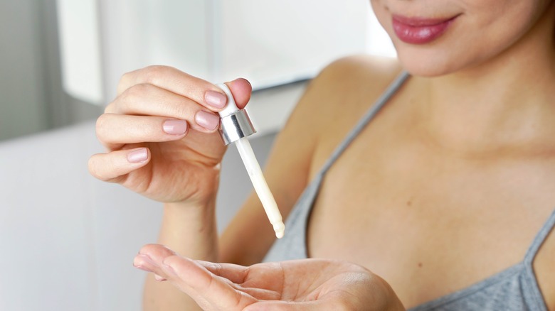 Woman applying vitamin C serum