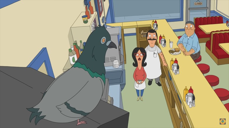 Still of Linda, Bob, and Teddy looking up at a pigeon indoors on "Bob's Burgers"