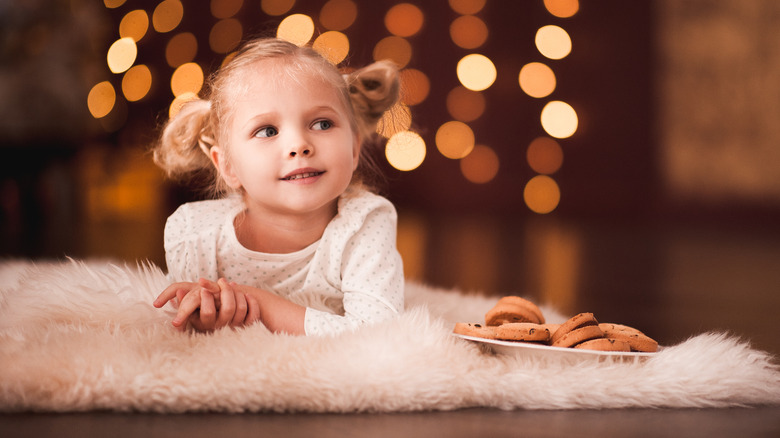 blonde toddler girl with pigtails christmas and cookies