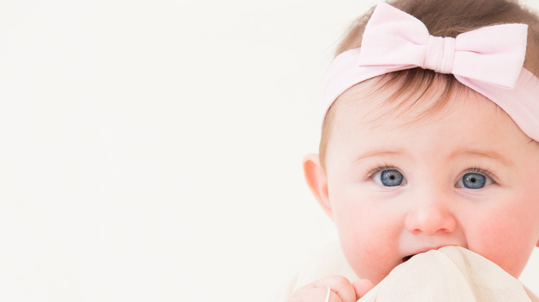 blue-eyes baby girl with pink bow