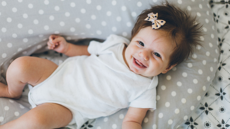 smiling baby with bow in hair