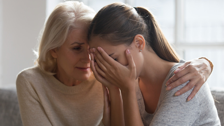 Older woman hugging younger woman