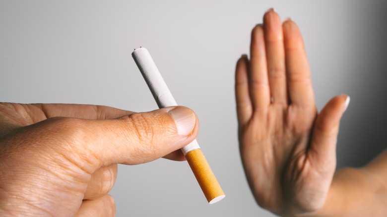 A hand refusing a cigarette 