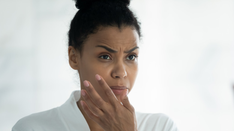 woman looking confused in mirror