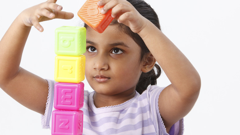 child building with alphabet blocks