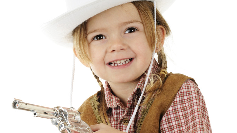 baby dressed as cowgirl with pistol