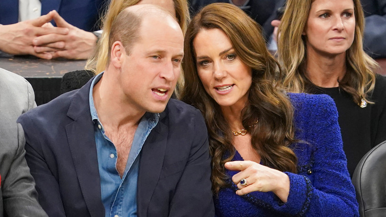 The Prince and Princess of Wales confer at a basketball game