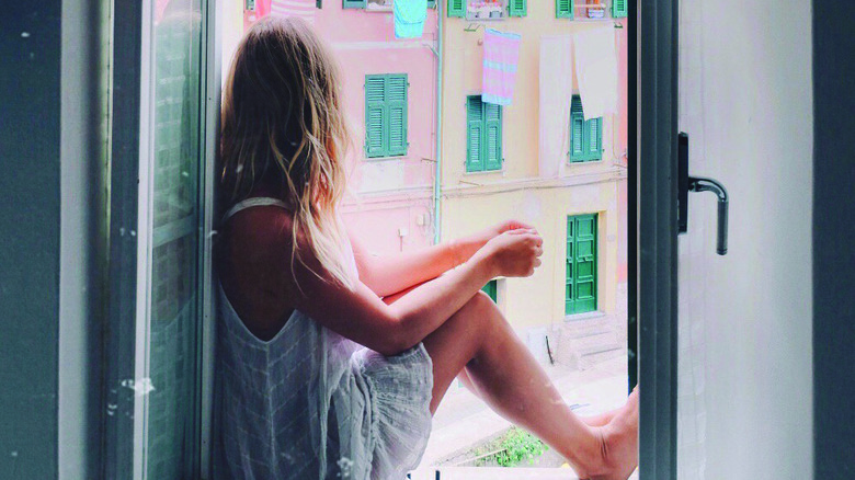 Anna Kloots looking out window in Europe