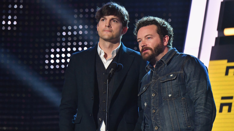 Ashton Kutcher and Danny Masterson standing on stage in front of a microphone together