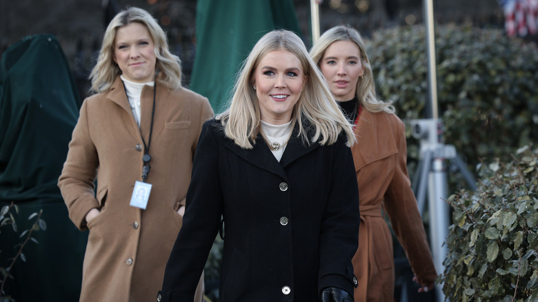 Karoline Leavitt walks in front of two women