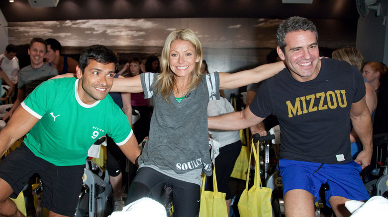 Mark Consuelos, Kelly Ripa, and Andy Cohen riding recumbent bikes