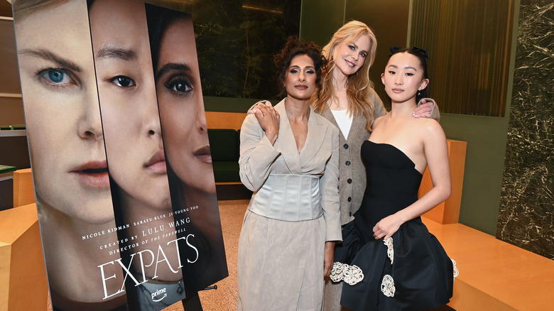 Sarayu Blue, Nicole Kidman, and Ji-young Yoo posing next to an "Expats" poster