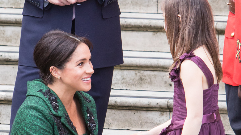 Meghan Markle receiving flowers from a young girl