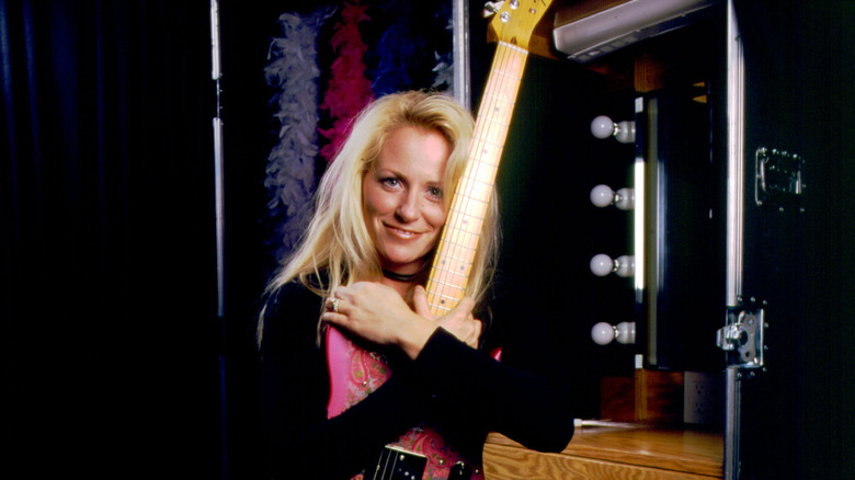 Deana Carter posing with a guitar in the 90s