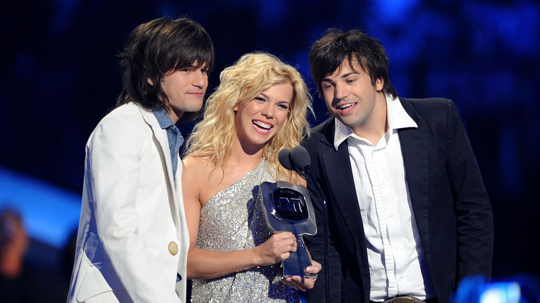 Members of The Band Perry posing with a CMT award