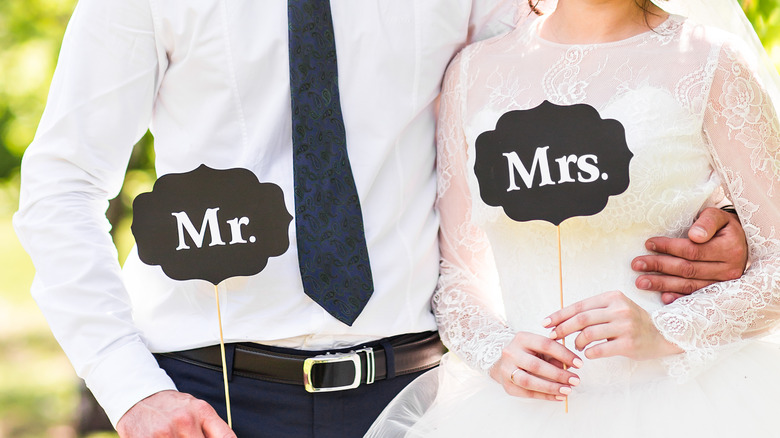 Married couple holding Mr. and Mrs. signs