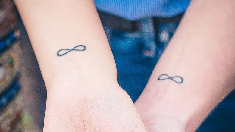 Couple with matching infinity sign tattoos