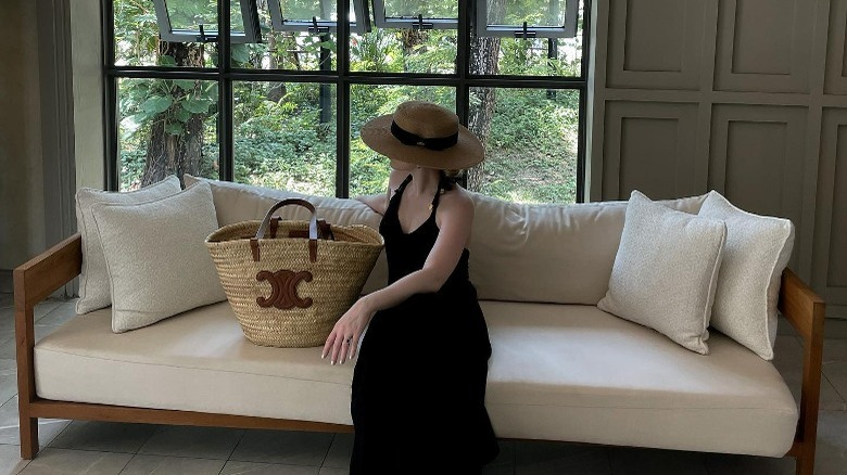 woman sitting on bench with tote