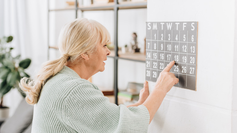 woman looking at wall calendar