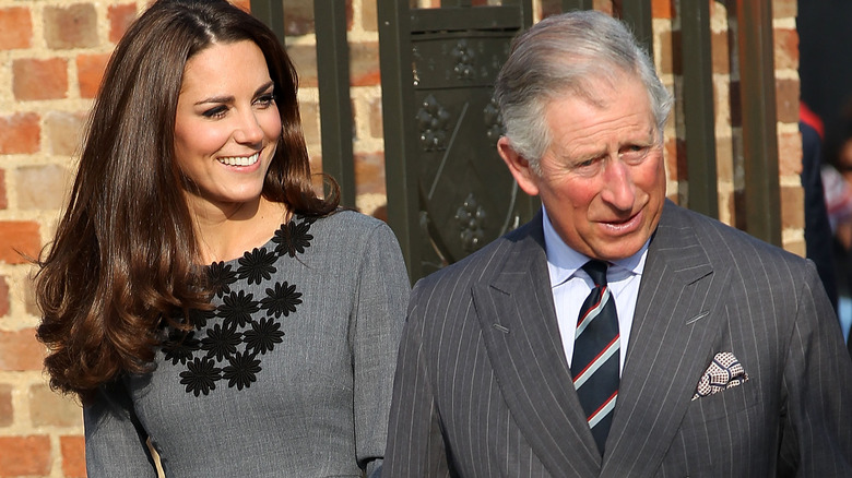 Kate Middleton smiling, standing next to King Charles, speaking