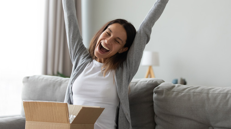 A happy woman celebrates after opening a package