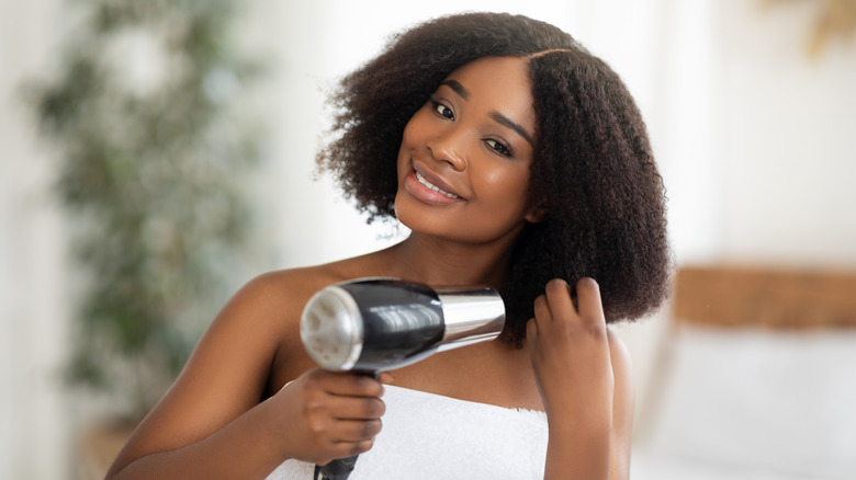 Woman blow-drying curly hair