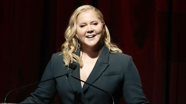 Amy Schumer speaking over a microphone