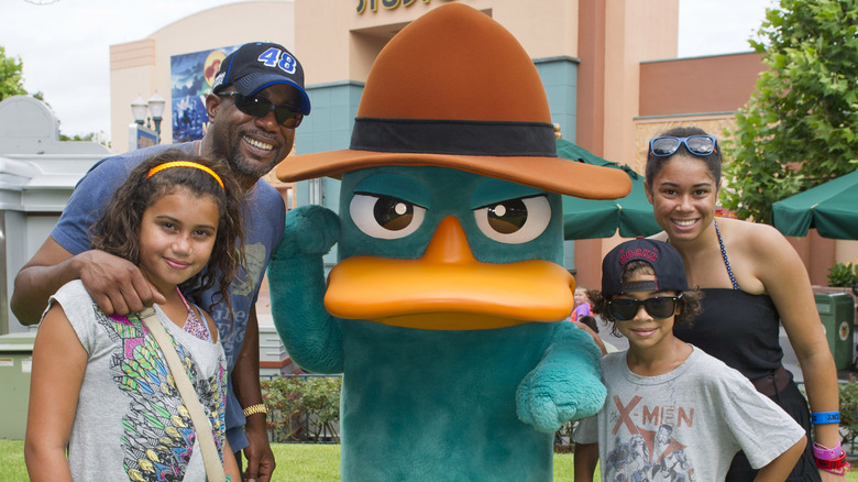 Darius Rucker, Daniella Rucker, Jack Rucker, and Carolyn Rucker standing next to Agent P mascot