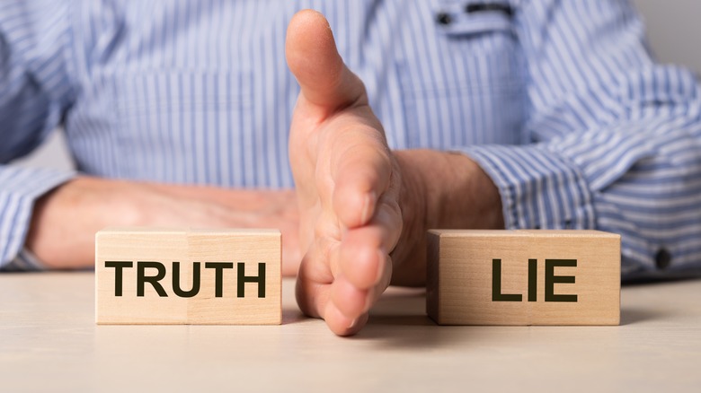 Two wooden blocks featuring the words truth and lie, respectively