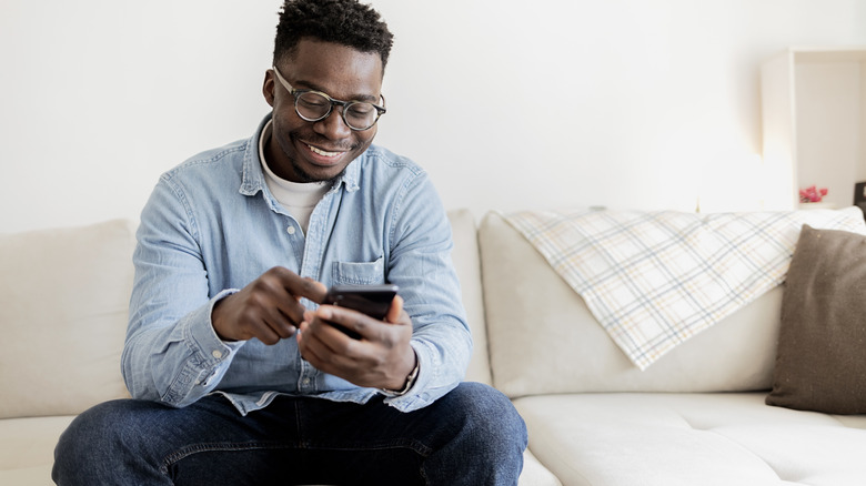 Man smiling while checking his phone