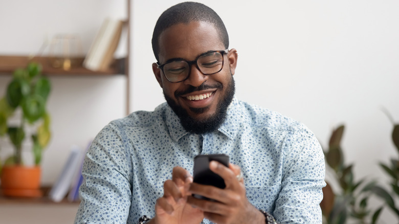 Man texting with a smile on his face