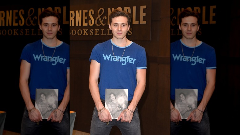 Brooklyn Beckham holding his photography book