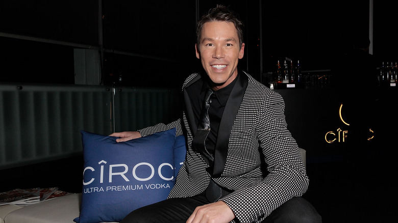 David Bromstad posing with a promotional photo in 2013