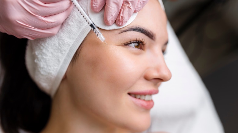 smiling woman getting face injection